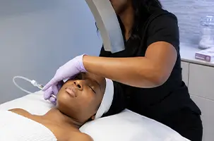 Overhead lamp positioned as a provider begins a HydraFacial in Deep Ellum on a reclined client