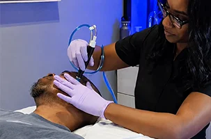 Client receiving a hydrating facial treatment at an IV therapy clinic near Uptown Dallas.