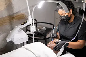 Licensed provider performing a SkinPen Lake Highland microneedling treatment under a magnifying lamp
