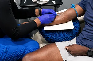 Vitamin injection Greenville provider administering a wellness shot into a seated client's arm