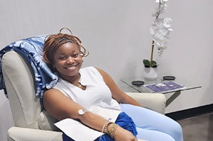 Woman smiling in a treatment chair after receiving a vitamin injection Oak Lawn wellness service