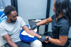 Client receiving a quick vitamin injection from a nurse during IV therapy near Uptown Dallas.